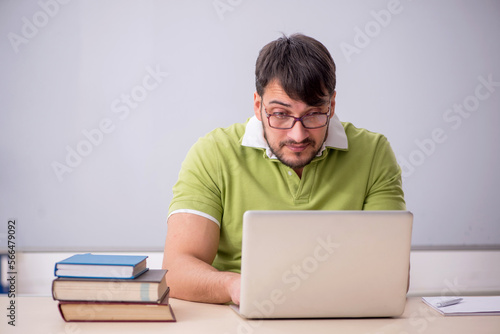 Young male teacher student in the classroom