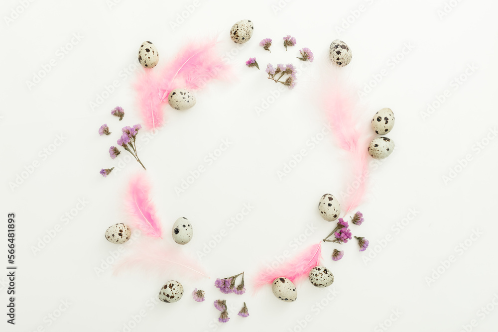 Round composition with easter eggs, flowers and feathers on white background. Flat lay, top view Round composition with easter eggs, flowers and feathers on white background. Flat lay, top view