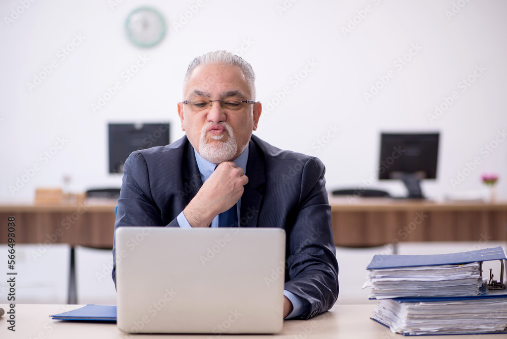 Old male employee working in the office Old male employee working in the office