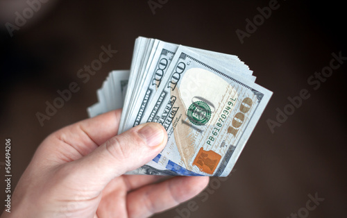 Close up male hand Counting and holding money us dollar. The concept of financial business and crisis.