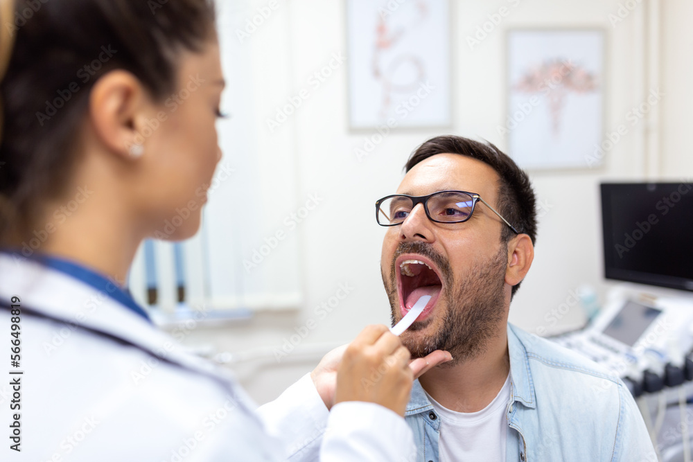 Male patient opening his mouth for the doctor to look at his throat