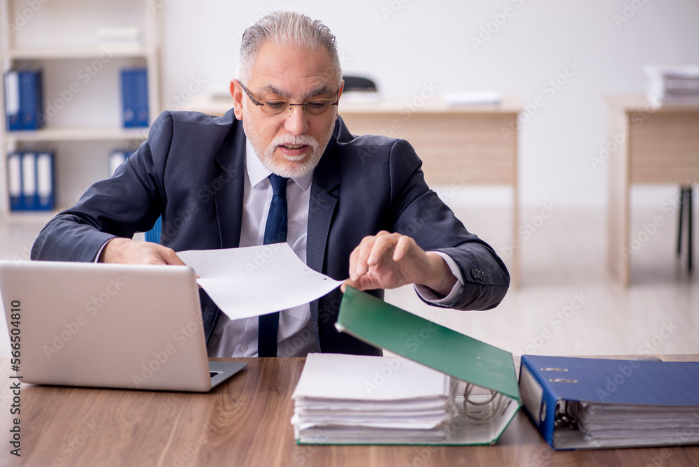 Old male employee working in the office Old male employee working in the office