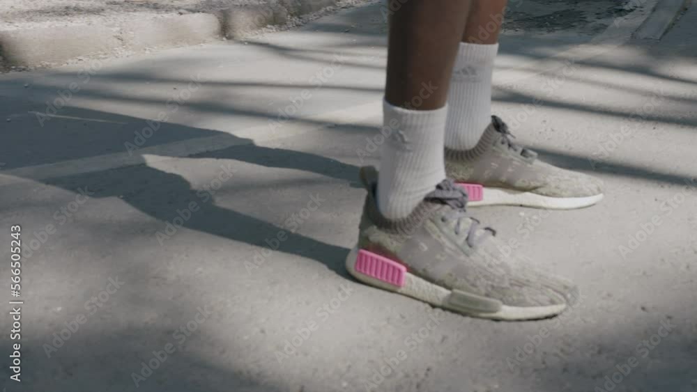 Persona de pie en el pavimento con zapatillas deportivas Persona de pie en el pavimento con zapatillas deportivas