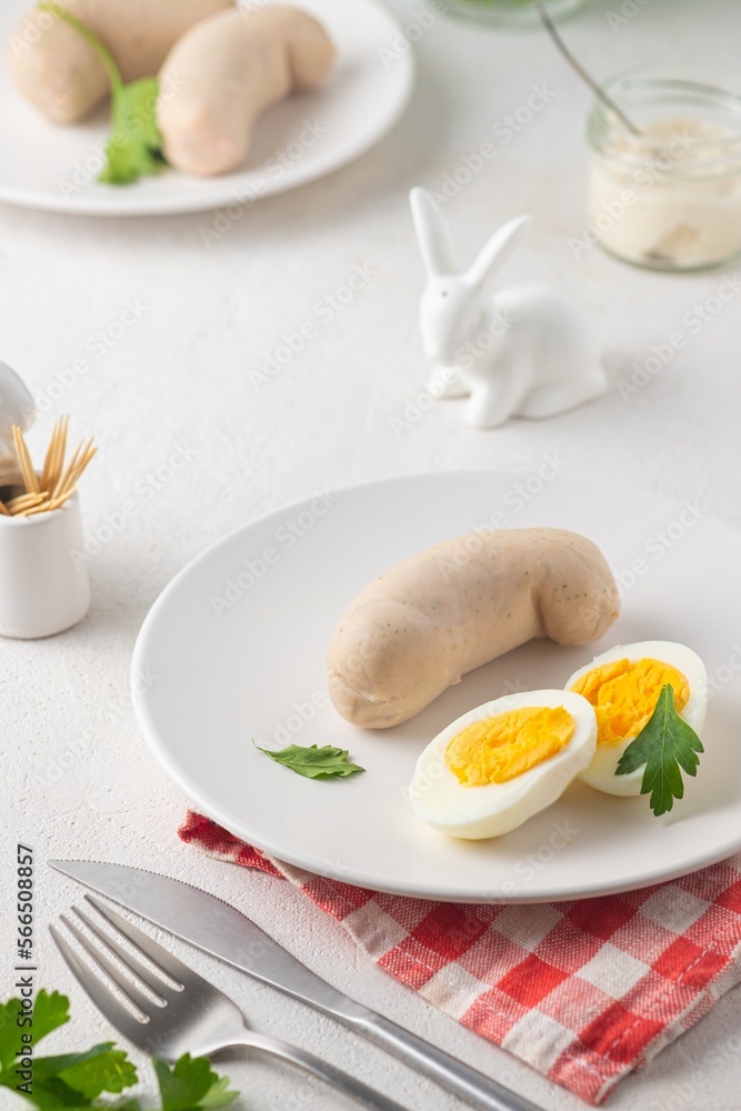 Polish Easter breakfast, white sausage and boiled egg on a white plate on a light concrete background. Served with white horseradish. Polish Easter breakfast, white sausage and boiled egg on a white plate on a light concrete background. Served with white horseradish.