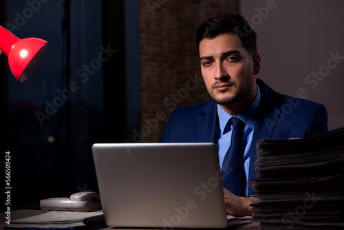 Young male employee working late in the office