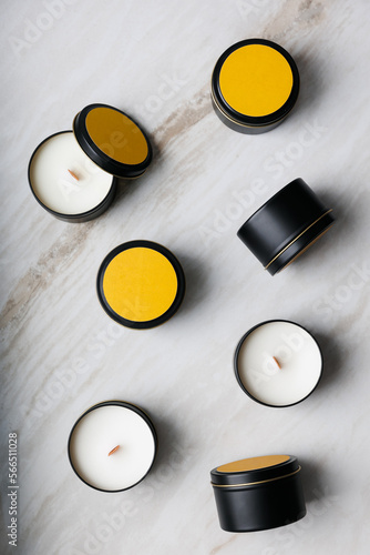 Group of wax candles in a tin box view from above against a background of marble. 