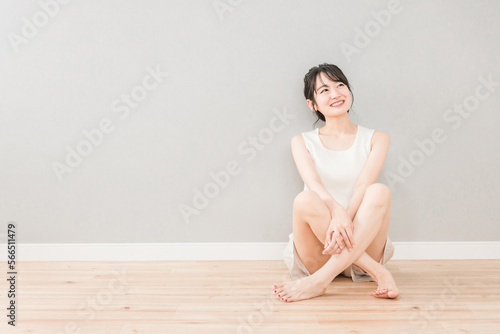 家のリビングに座る美人のアジア人女性（美容・ダイエット・エステ・脱毛・コピースペース） 