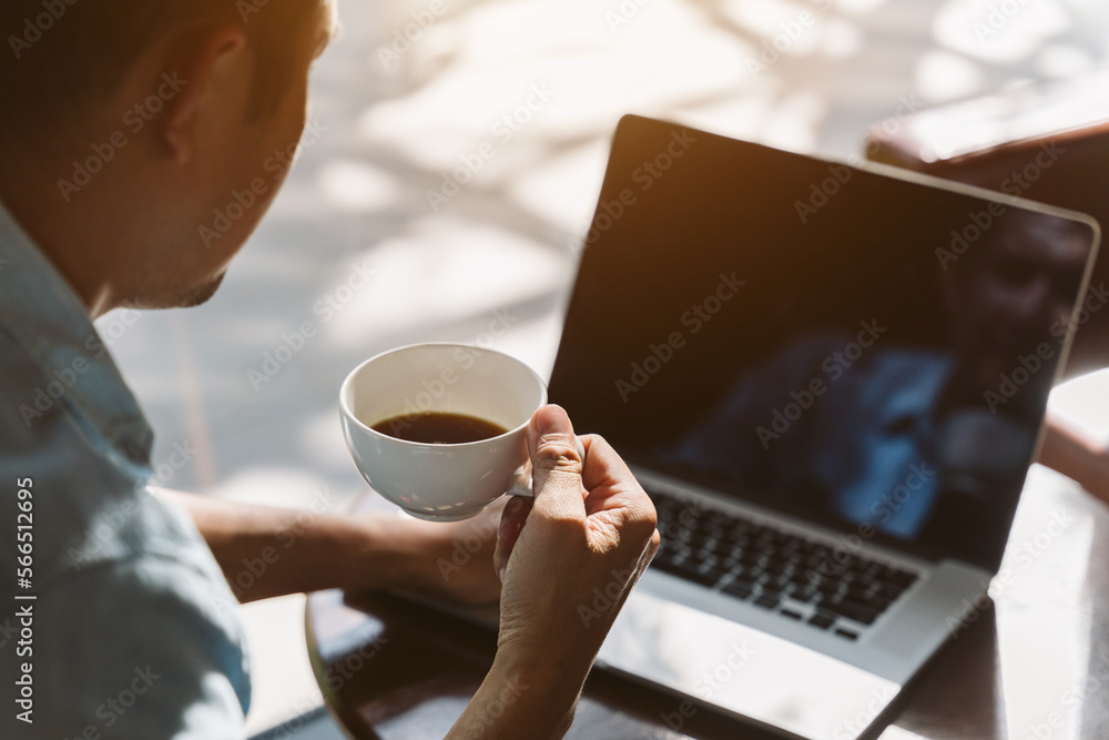 Asian businessman or freelancer drinking coffee and working in a cafe. close up of coffee mug. Asian businessman or freelancer drinking coffee and working in a cafe. close up of coffee mug.