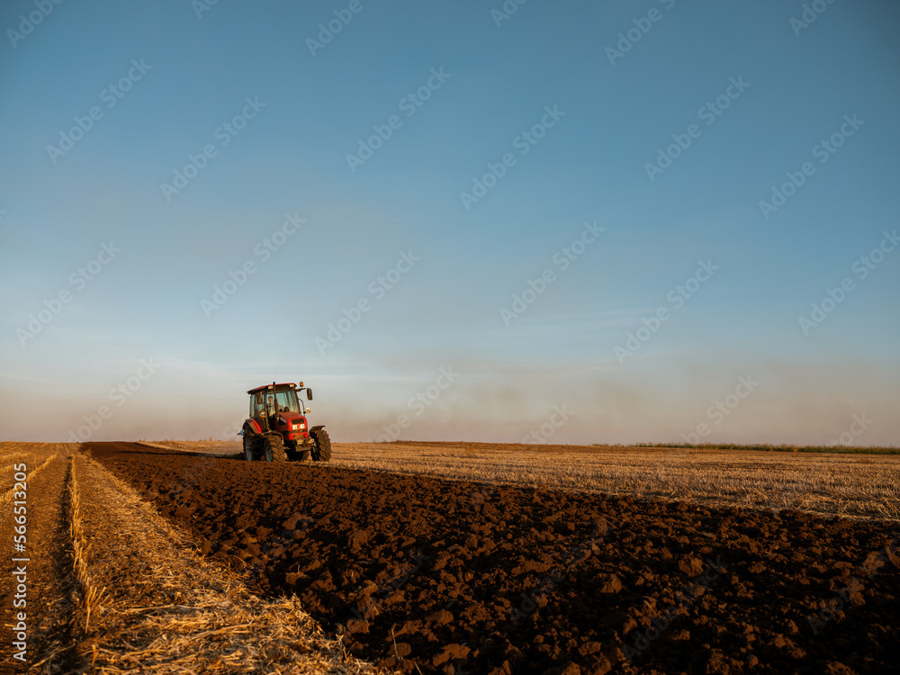 Tractor plowing and preparing stubble field for cultivation and planting Tractor plowing and preparing stubble field for cultivation and planting
