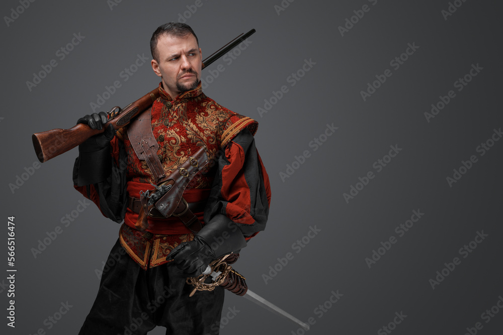 Shot of medieval musketeer man dressed in antique stylish suit holding rifle. Shot of medieval musketeer man dressed in antique stylish suit holding rifle.