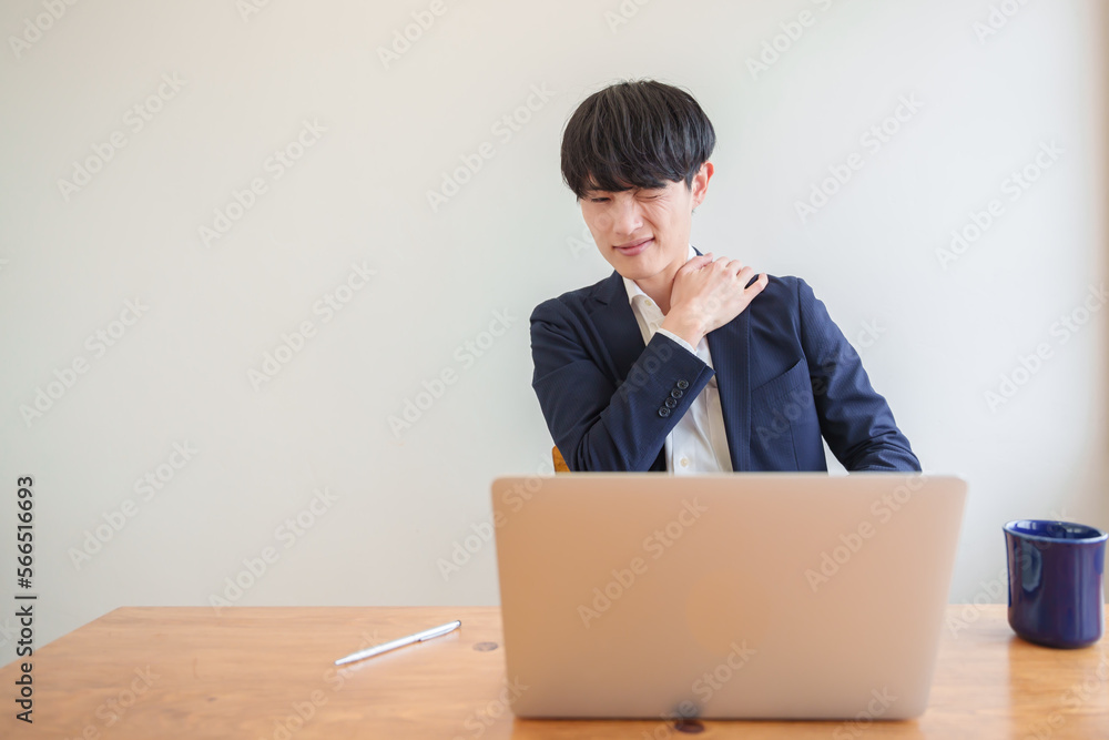 肩こりで顔を顰める男性ビジネスパーソン Stock Photo | Adobe Stock