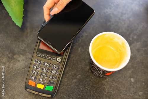 Electronic payments, online payments concept. Bank card inserted to payment terminal near computer keyboard on black background top view copy space photo