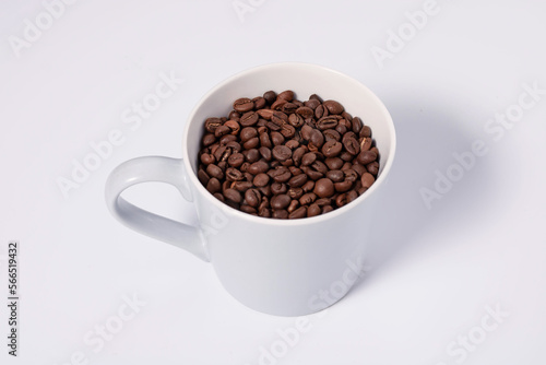 top view photo of mug full of coffee beans on white background