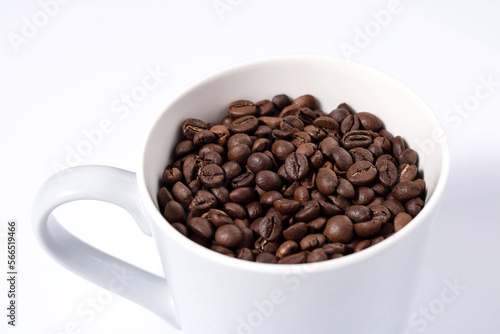 top of mug full of coffee beans on white background close up horizontal photo