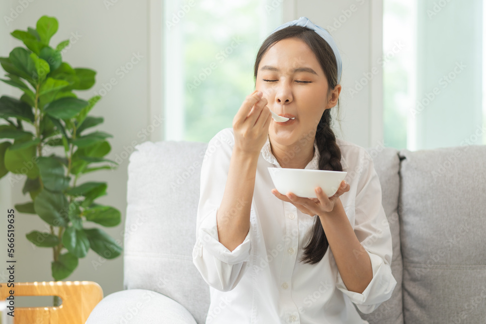 Healthy lifestyle, wellness food asian young woman hand use spoon eat tasty fresh organic yogurt, dairy product in bowl breakfast meal at home. Snack tasty on diet nutrition delicious natural yoghurt Healthy lifestyle, wellness food asian young woman hand use spoon eat tasty fresh organic yogurt, dairy product in bowl breakfast meal at home. Snack tasty on diet nutrition delicious natural yoghurt