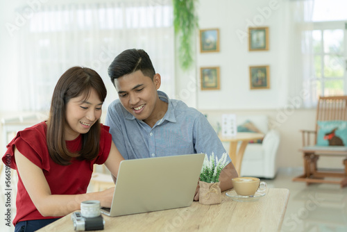 Asian couple using computer planning to travel.
