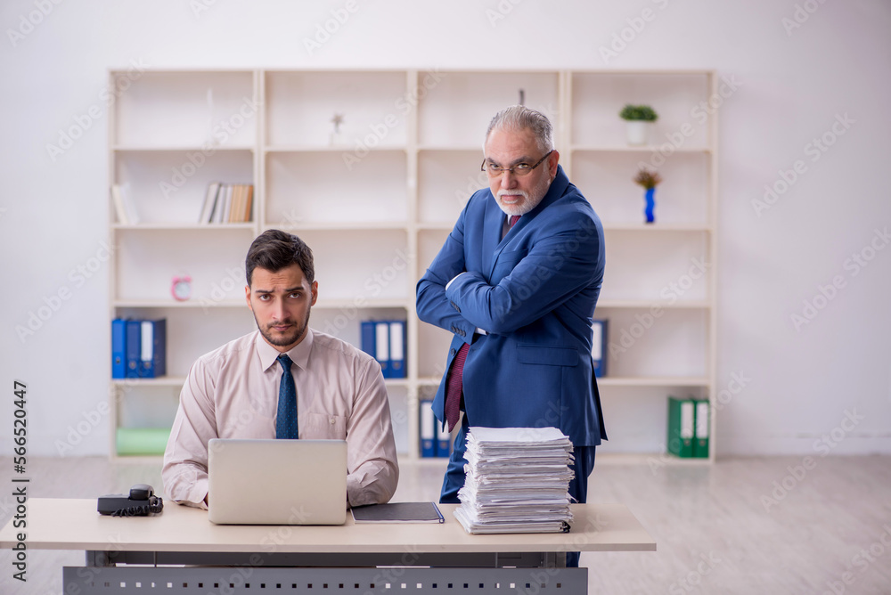 Old male boss and young male employee in bullying concept Old male boss and young male employee in bullying concept