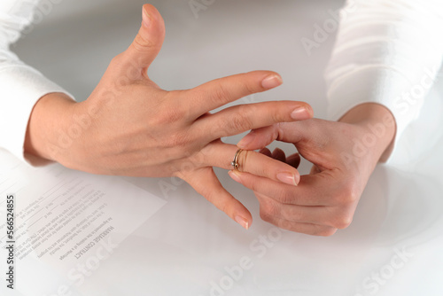 Relationship breakup, woman taking off her engagement ring from her finger