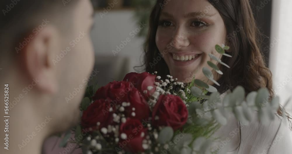 Young man gives a bouquet of roses to his girlfriend Young man gives a bouquet of roses to his girlfriend
