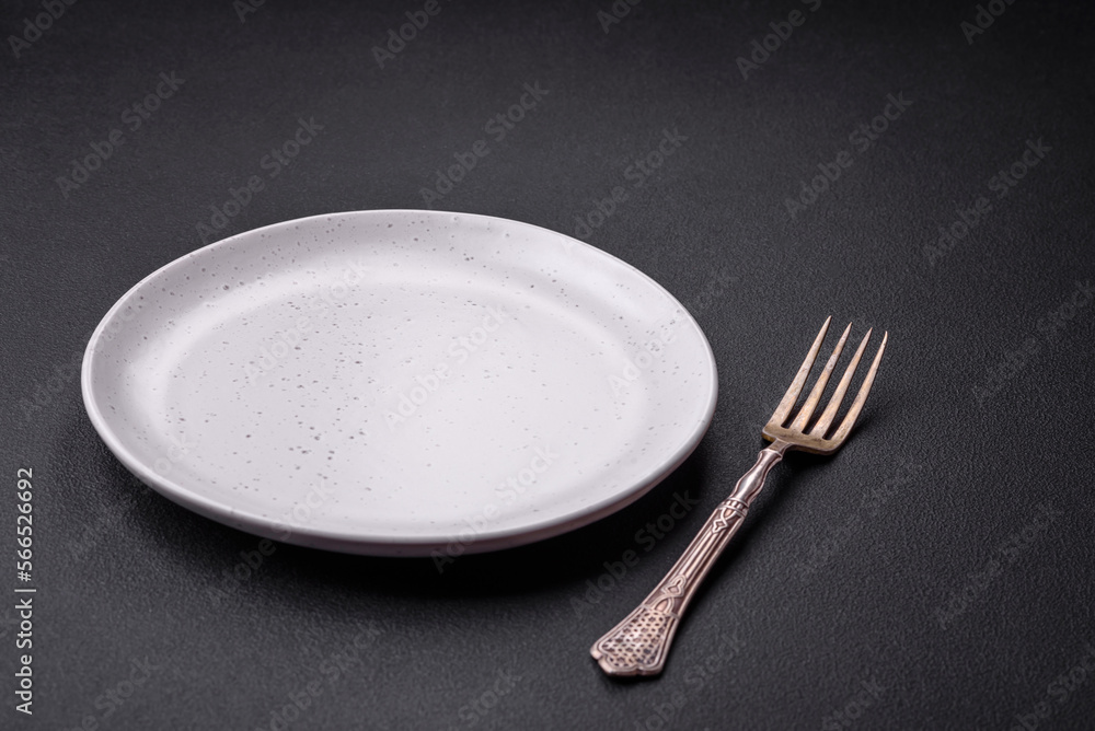 Empty ceramic round plate on dark textured concrete background Empty ceramic round plate on dark textured concrete background