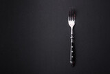 Metal kitchen fork on a dark textured concrete background