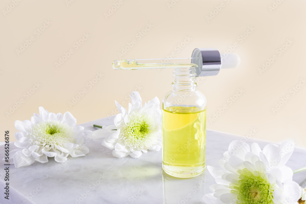 an open cosmetic bottle filled with a pipette of natural organic oil or serum for face and body care. beige background. marble podium. an open cosmetic bottle filled with a pipette of natural organic oil or serum for face and body care. beige background. marble podium.