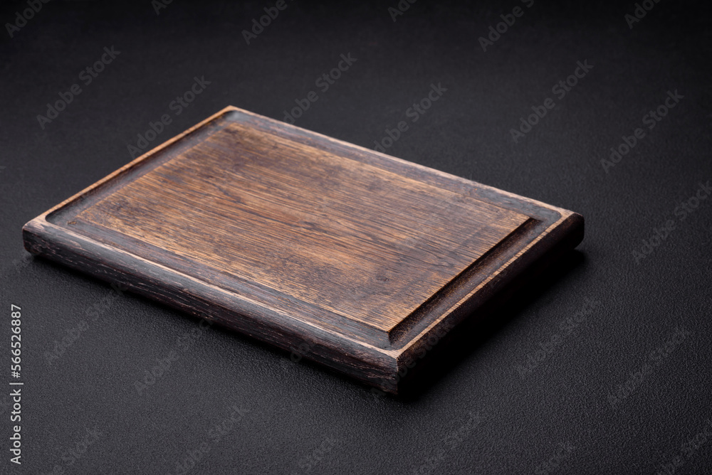 Empty wooden cutting board on dark textured concrete background Empty wooden cutting board on dark textured concrete background