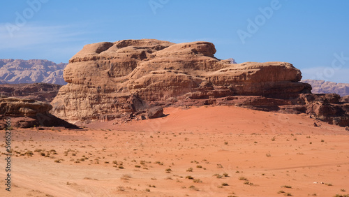 Fotografie Large red sand dunes and rugged sandstone mountainous landscape in remote wilder