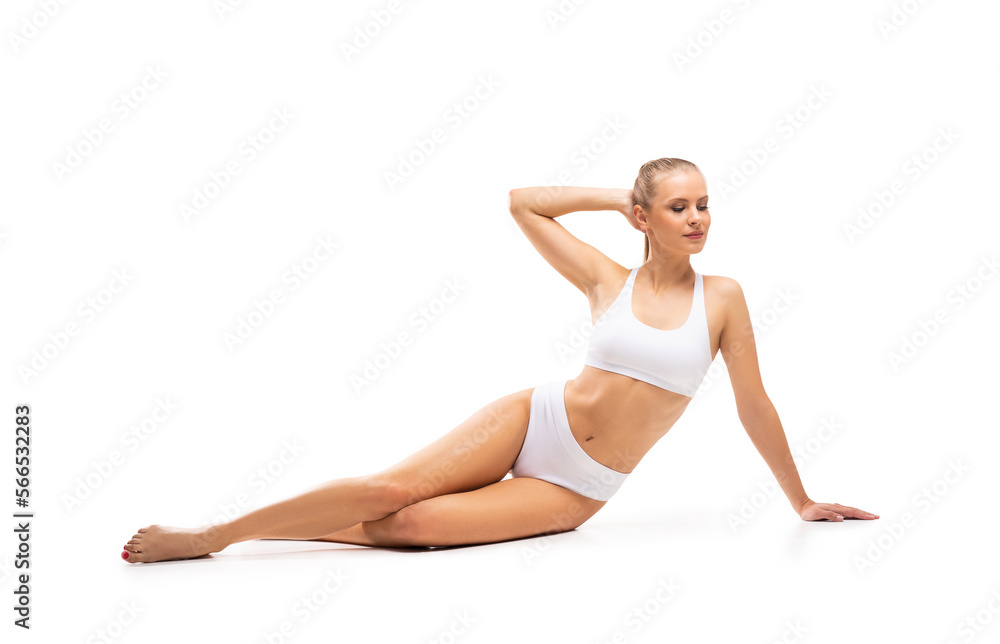 Young, fit and beautiful blond woman in white swimsuit isolated on grey background. Healthcare, diet, sport and fitness concept. Young, fit and beautiful blond woman in white swimsuit isolated on grey background. Healthcare, diet, sport and fitness concept.