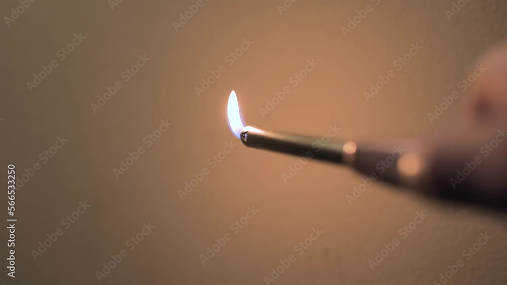 Igniting a long lighter in front of white background Igniting a long lighter in front of white background