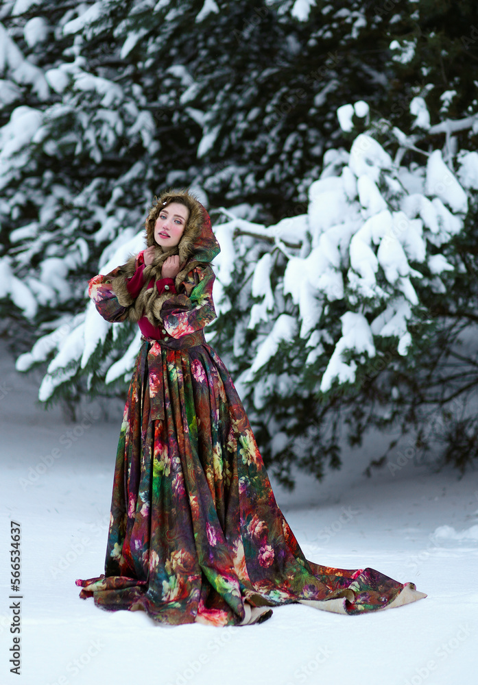 Beautiful young woman in red historical dress walking on snow in winter forest. Traditional portrait of russian woman