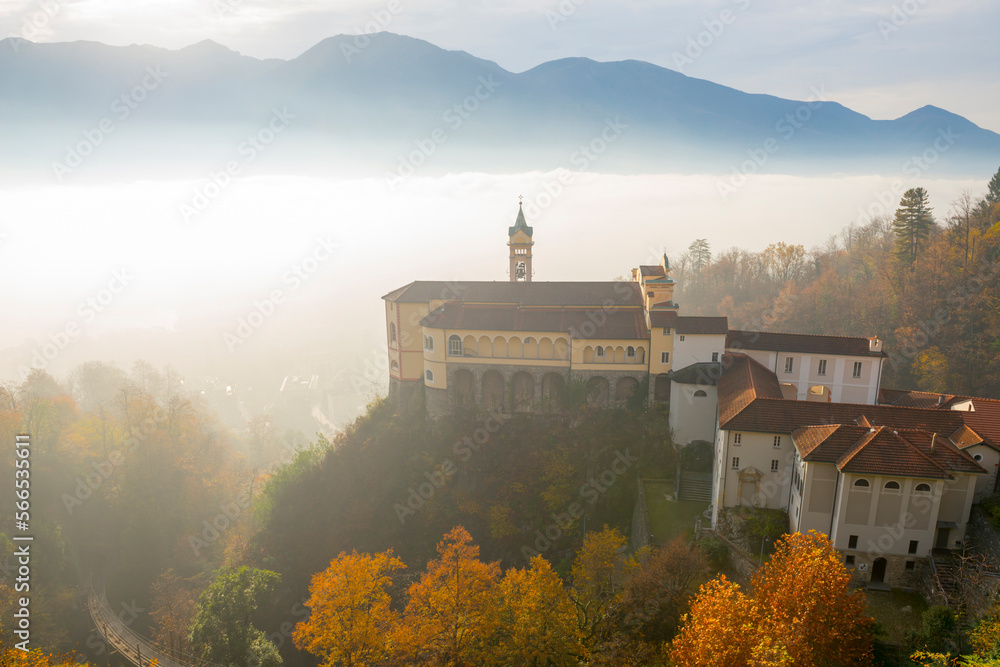 Monastery Madonna del Sasso in the Fog with Sunlight in Locarno, Ticino in Switzerland.