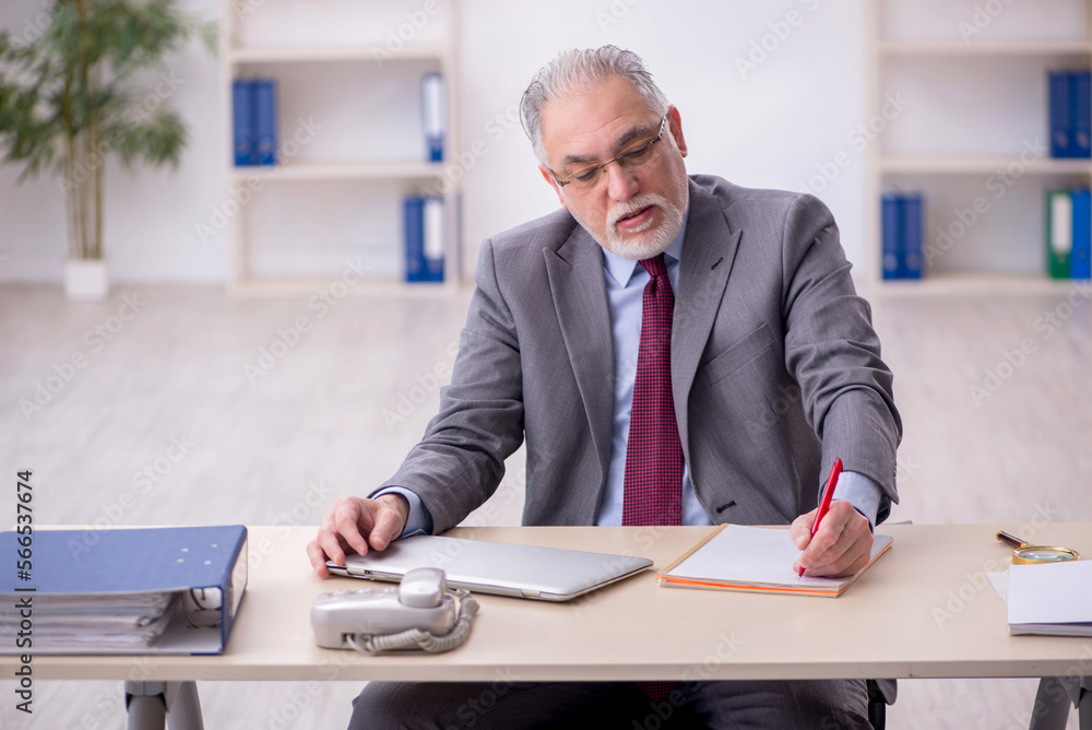 Old male employee working in the office Old male employee working in the office