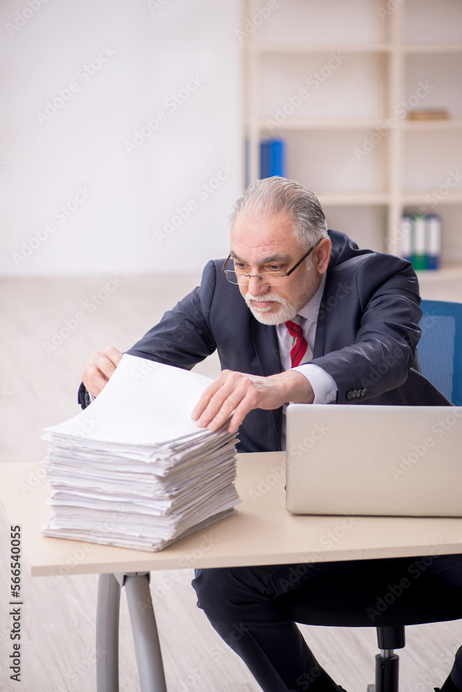 Old male employee and too much work at workplace Old male employee and too much work at workplace