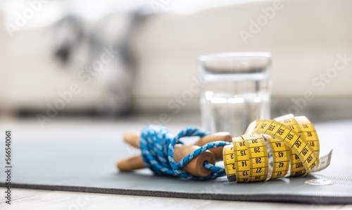 Photography A skipping rope, a tape measure and a glass of water on a mat at home in the living room