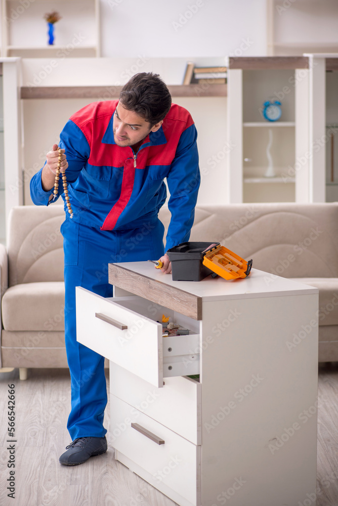 Young male carpenter stealing jewelry at home