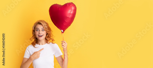 amazed redhead lady pointing finger on romantic gift of party balloon. happy valentines day. Beautiful woman isolated face portrait, banner with mock up copy space. © Olena