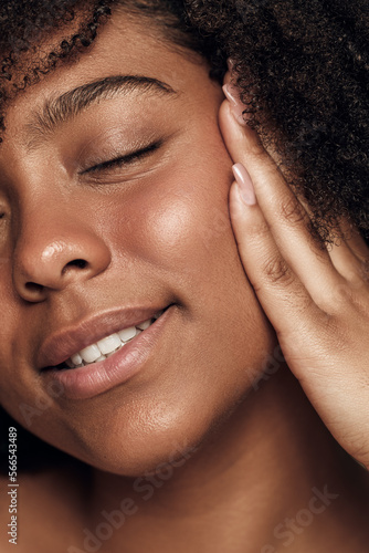 Crop happy young ethnic lady smiling with closed eyes while touching face