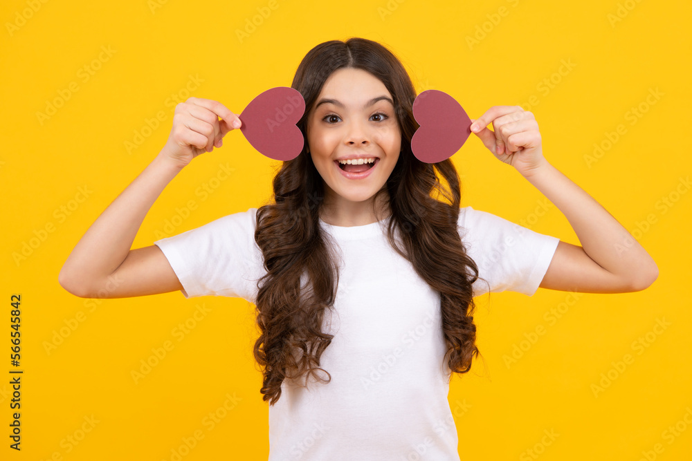 Happy teenager, positive and smiling emotions of teen girl on yellow background. Lovely child girl 12, 13, 14 years old with shape heart love holiday and valentine symbol. Valentine or birthday day. Happy teenager, positive and smiling emotions of teen girl on yellow background. Lovely child girl 12, 13, 14 years old with shape heart love holiday and valentine symbol. Valentine or birthday day.