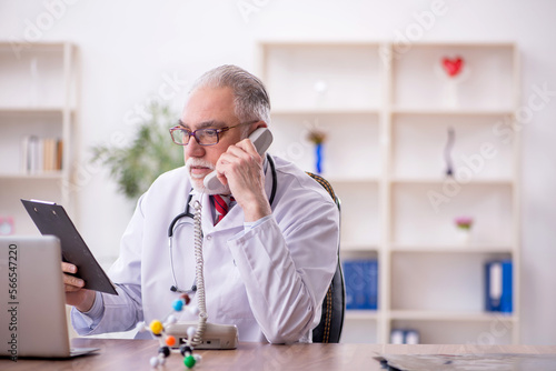 Old male doctor in telemedicine concept