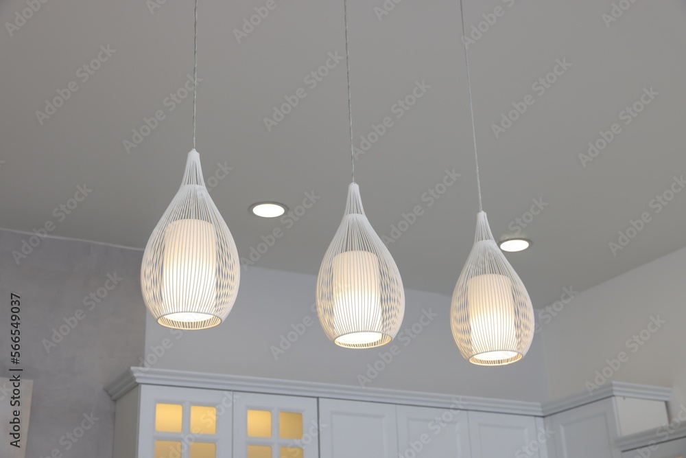 Ceiling with modern lamps and furniture in stylish kitchen, low angle view Ceiling with modern lamps and furniture in stylish kitchen, low angle view