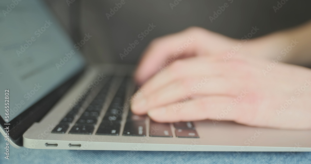 Female fingers typing on a laptop keyboard, side view. Female fingers typing on a laptop keyboard, side view.