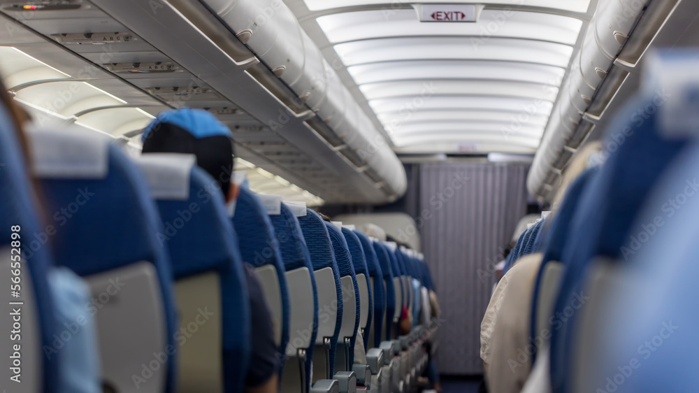 Naklejka premium Passenger seat. Interior of airplane with passengers sitting on seats. Plane cabin. The interior of the aircraft with passengers on seats.