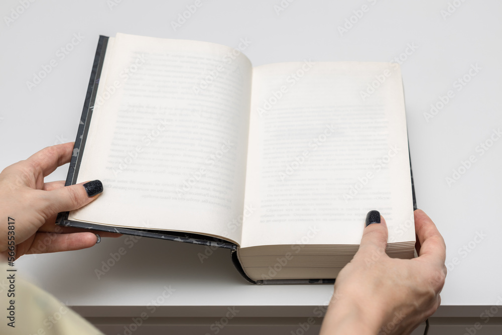 Fototapeta premium man opens a thick book lying on the table.