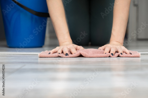 woman washing the floor in the room with a rag