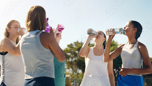 Foto Athletic woman, friends and drinking water for hydration during sports workout, training or practice together outside