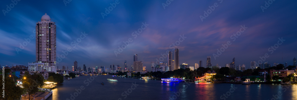 Fototapeta premium Panoramic Bangkok cityscape. Night view of tall buildings and Chao Phraya river in business district. Nightfall. Bangkok,Thailand