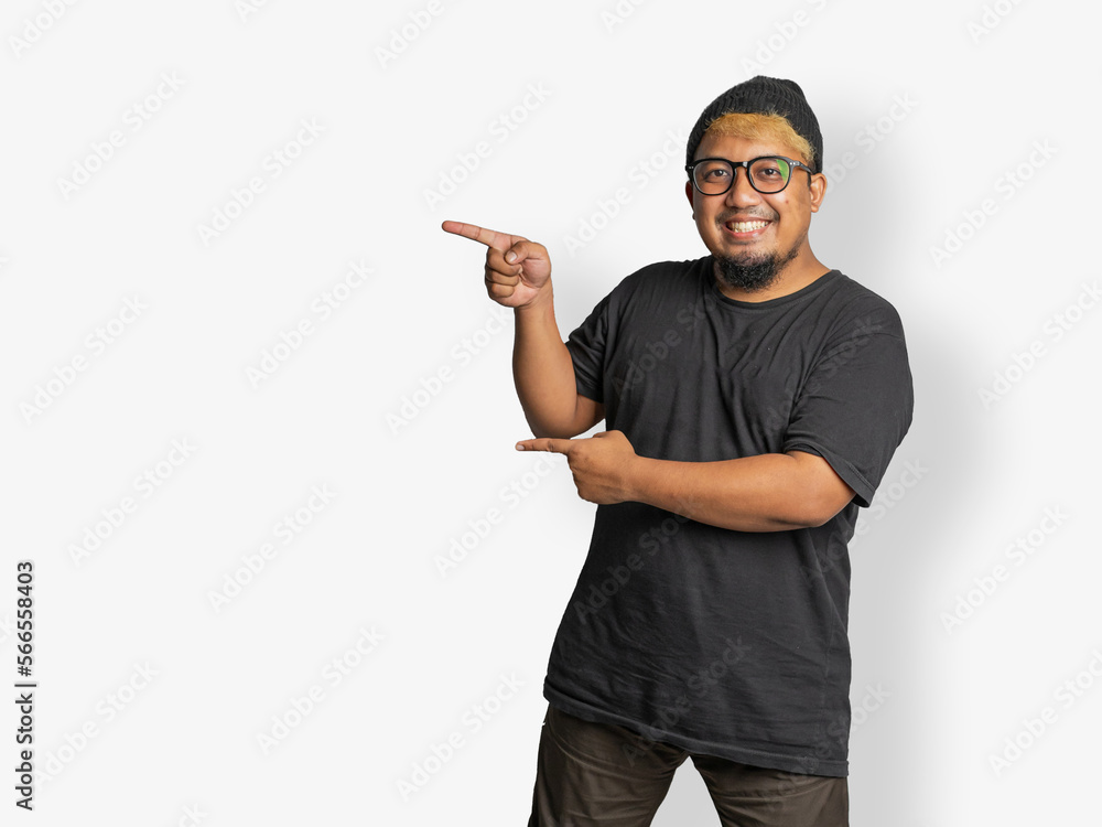 Asian man set pointing with two hand in left direction. A casual people with cap and glass use black t-shirt with joyful emotions pointing looking at camera. photo with white background. excited man Asian man set pointing with two hand in left direction. A casual people with cap and glass use black t-shirt with joyful emotions pointing looking at camera. photo with white background. excited man