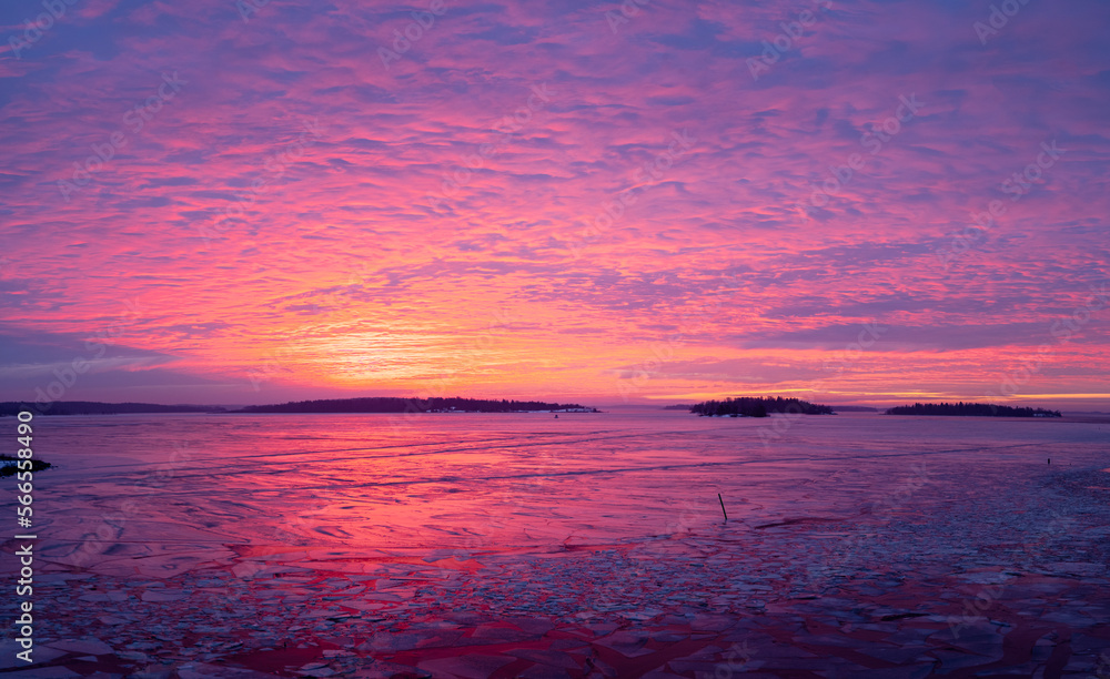 Panorama view of winter landscape and colorful sunrise over the lake on a cold morning. Photo taken in Sweden.