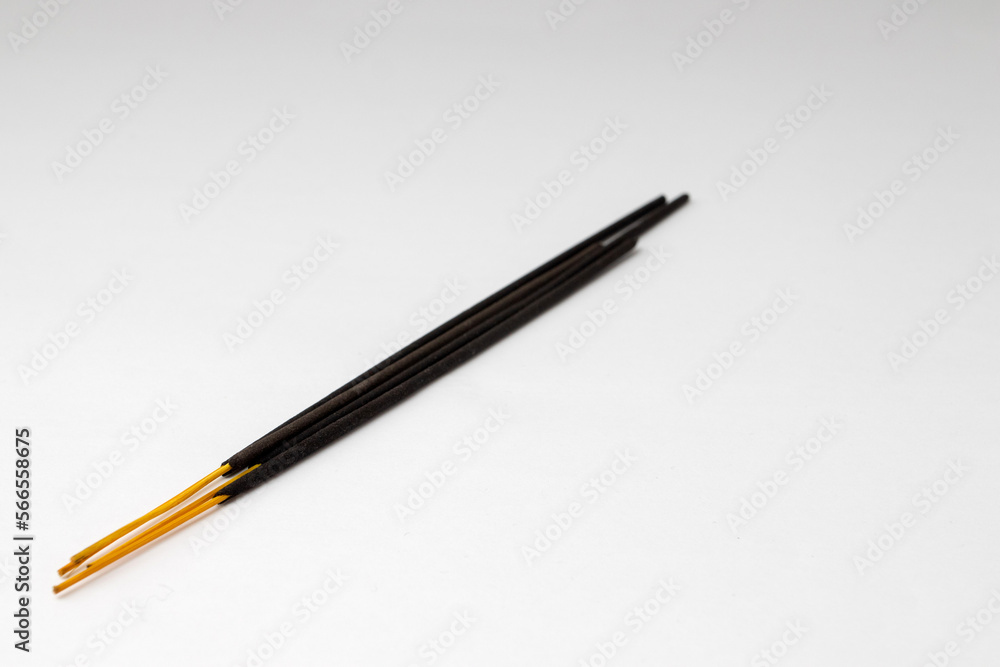 Black aromatic incense sticks on a white background Black aromatic incense sticks on a white background